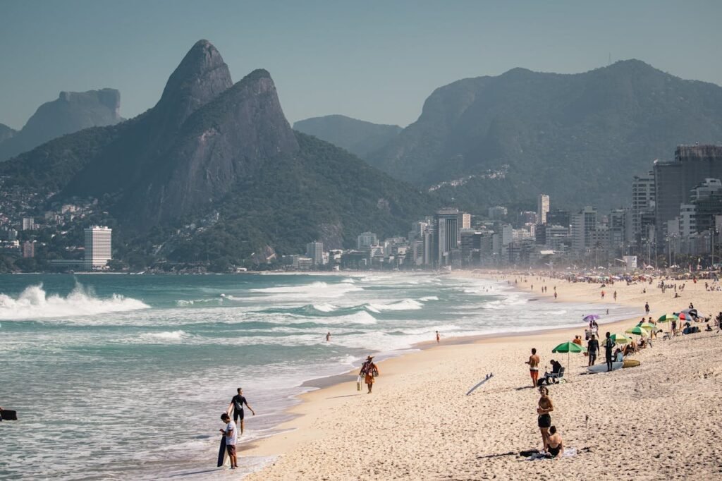 Waves crashing on the shore with mountains in the distance at Ipanema Beach, Brazil